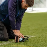 A Sports Labs specialist does testing on a sports field.