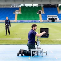 Two Sports Labs technicians test a field in the rain using the latest technology.